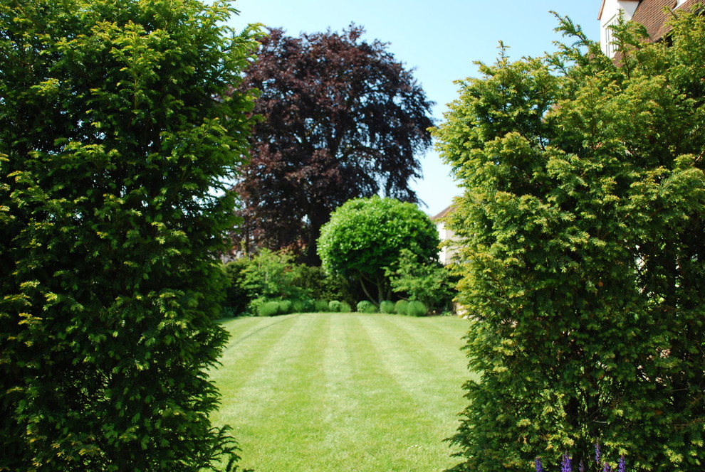 Imagen de jardín tradicional de tamaño medio en patio trasero con jardín francés