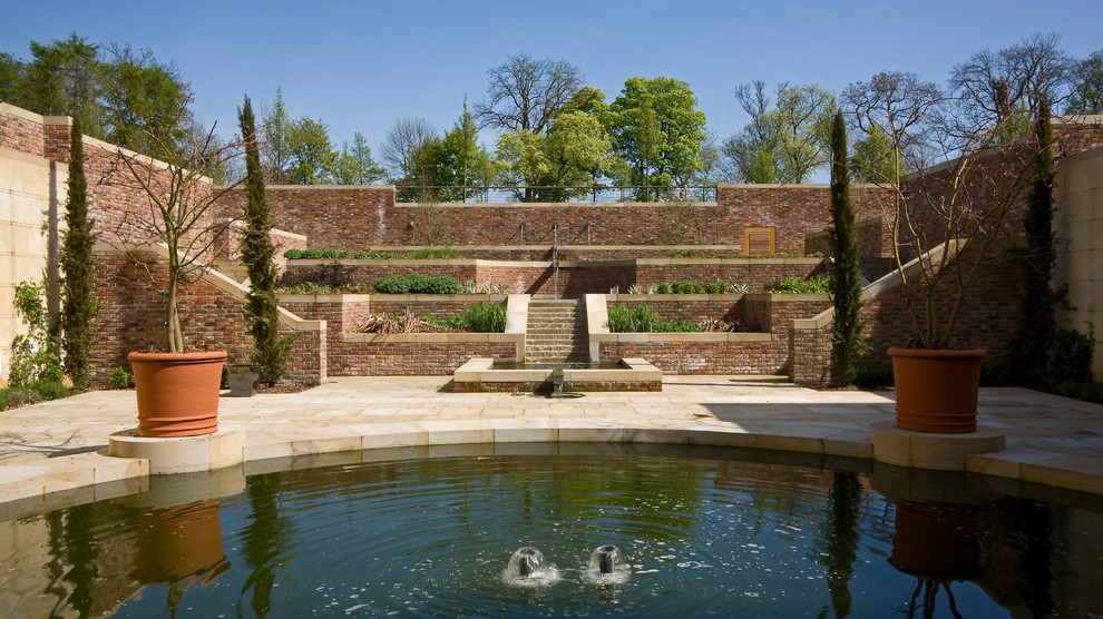 Esempio di un ampio giardino tradizionale dietro casa con fontane