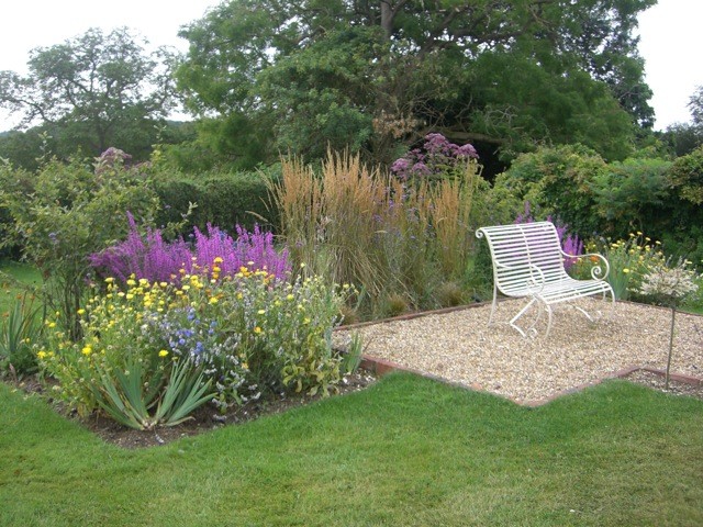 Источник вдохновения для домашнего уюта: большой солнечный, летний регулярный сад в классическом стиле с хорошей освещенностью и покрытием из гравия