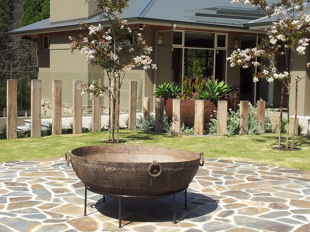 Idee per un grande giardino formale design esposto in pieno sole dietro casa con un focolare e pavimentazioni in pietra naturale