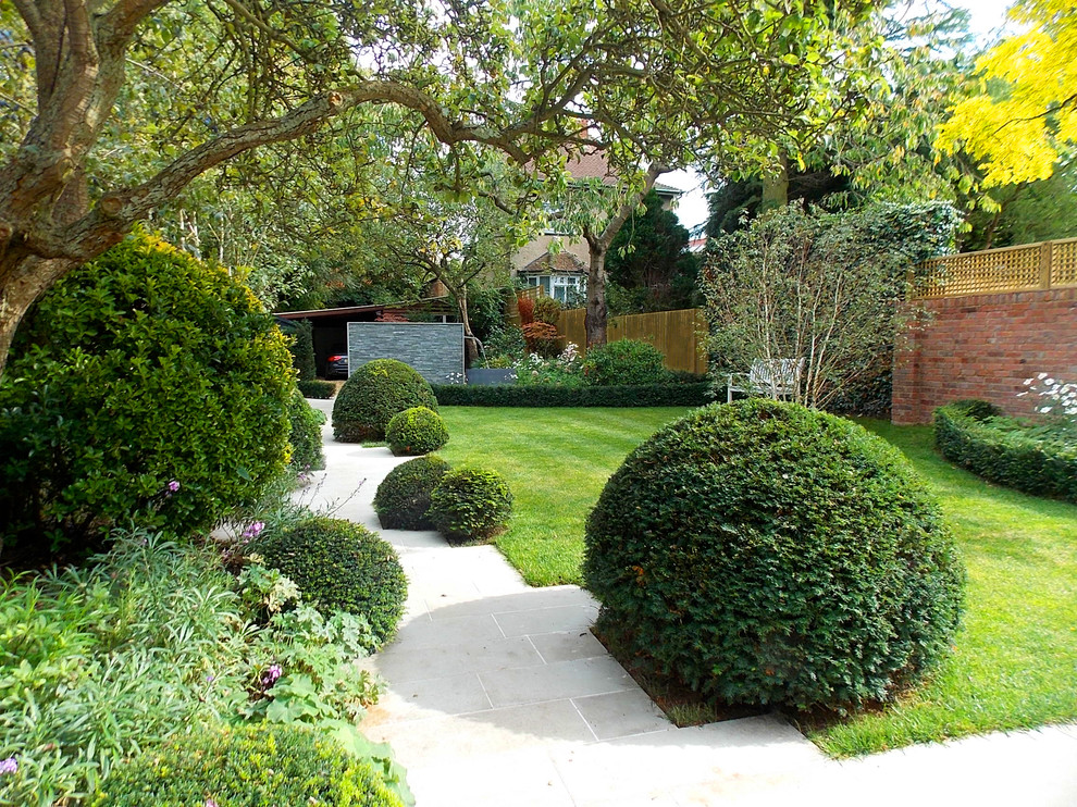 This is an example of a transitional full sun backyard landscaping in London.