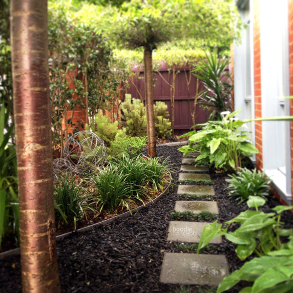 На фото: маленький тенистый, весенний участок и сад на переднем дворе в морском стиле с садовой дорожкой или калиткой и мощением тротуарной плиткой для на участке и в саду