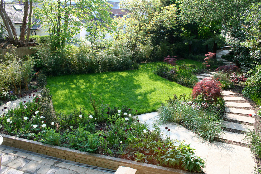 Design ideas for a mid-sized farmhouse shade backyard formal garden in Kent.