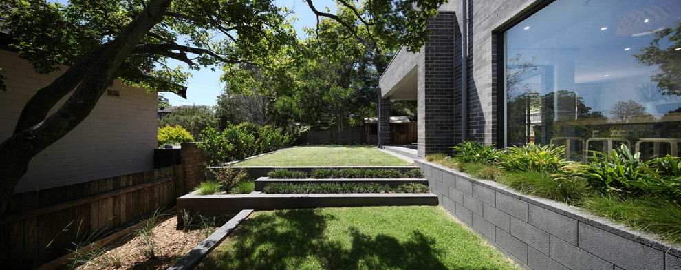 Пример оригинального дизайна: большой солнечный, летний участок и сад на заднем дворе в современном стиле с хорошей освещенностью