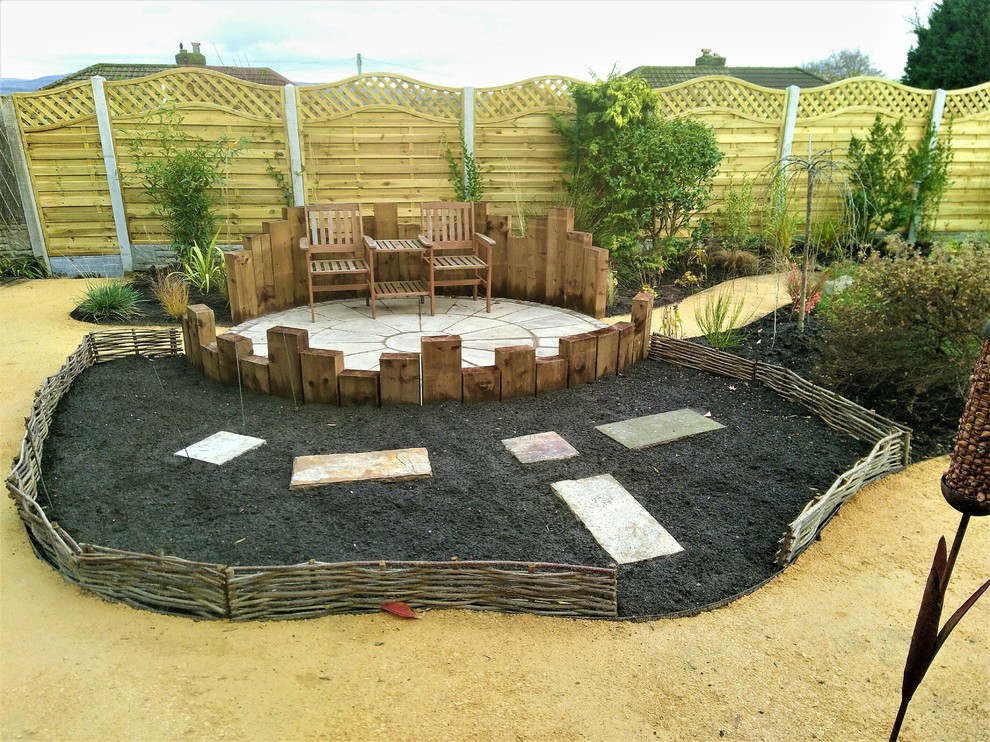 Diseño de jardín de tamaño medio en patio trasero con exposición parcial al sol y adoquines de piedra natural