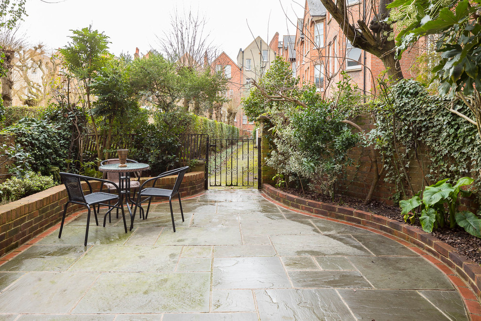 Mittelgroßer Klassischer Garten hinter dem Haus mit Natursteinplatten in London