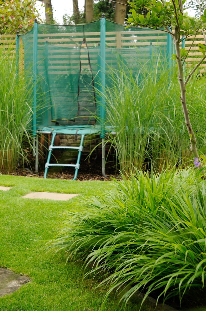 Mittelgroßer, Halbschattiger Moderner Garten im Sommer, hinter dem Haus mit Natursteinplatten
