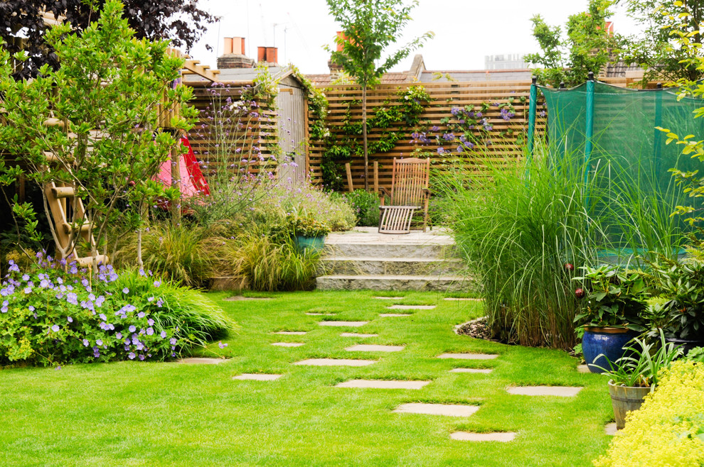 Diseño de jardín actual de tamaño medio en verano en patio trasero con exposición parcial al sol y adoquines de piedra natural