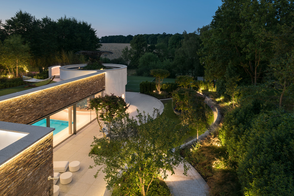Large contemporary roof formal full sun garden for summer in Hampshire with natural stone paving.