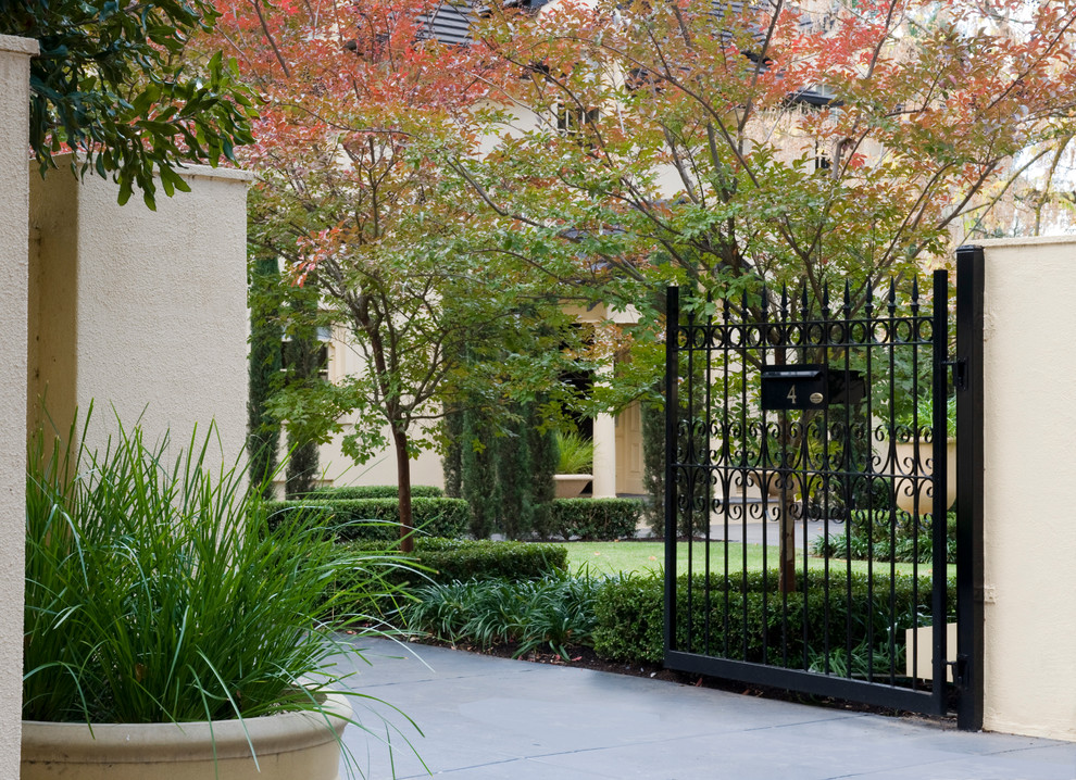 Esempio di un giardino formale tradizionale esposto a mezz'ombra di medie dimensioni e davanti casa in autunno con un ingresso o sentiero e pavimentazioni in pietra naturale