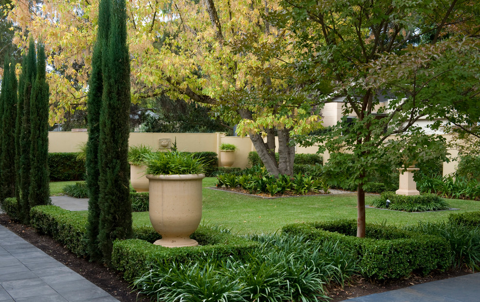 Photo of a mid-sized traditional partial sun front yard stone landscaping in Adelaide for fall.