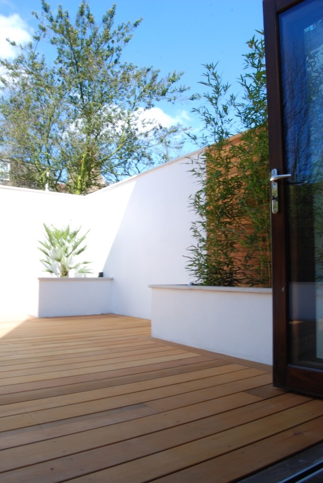 Пример оригинального дизайна: маленький засухоустойчивый сад на заднем дворе в современном стиле с полуденной тенью, покрытием из каменной брусчатки и подпорной стенкой для на участке и в саду