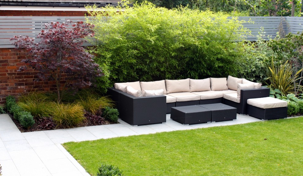 Design ideas for a medium sized contemporary back formal full sun garden for summer in Cheshire with a water feature and natural stone paving.