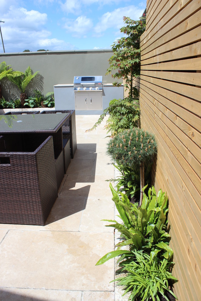 Esempio di un piccolo giardino formale minimal esposto in pieno sole dietro casa in estate con un giardino in vaso, pavimentazioni in pietra naturale e recinzione in legno