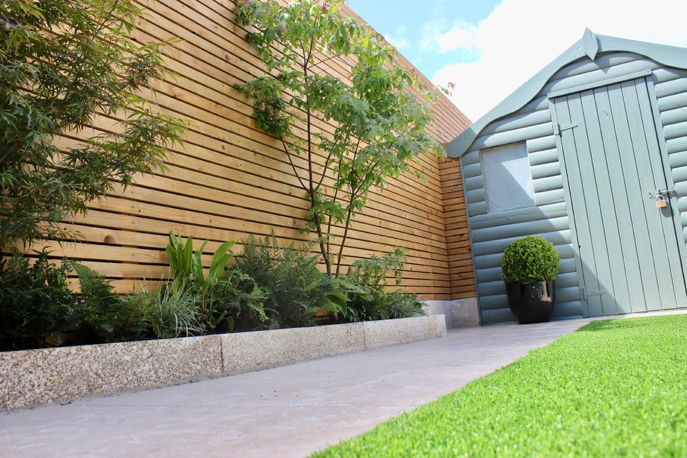 Geometrischer, Kleiner Moderner Garten im Sommer, hinter dem Haus mit Kübelpflanzen, direkter Sonneneinstrahlung, Natursteinplatten und Holzzaun in Dublin