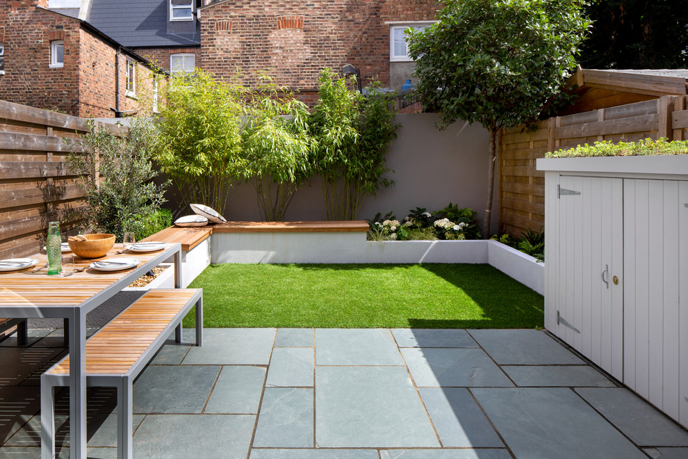 Design ideas for a small modern back xeriscape partial sun garden in London with concrete paving.