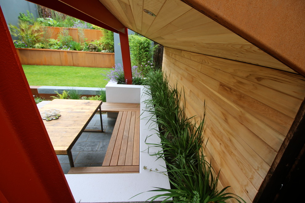 Esempio di un giardino design esposto a mezz'ombra dietro casa con pavimentazioni in pietra naturale