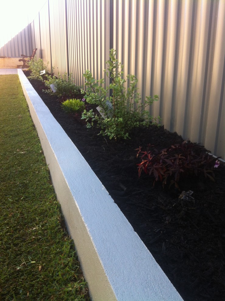 Photo of a small contemporary partial sun backyard mulch landscaping in Perth for summer.