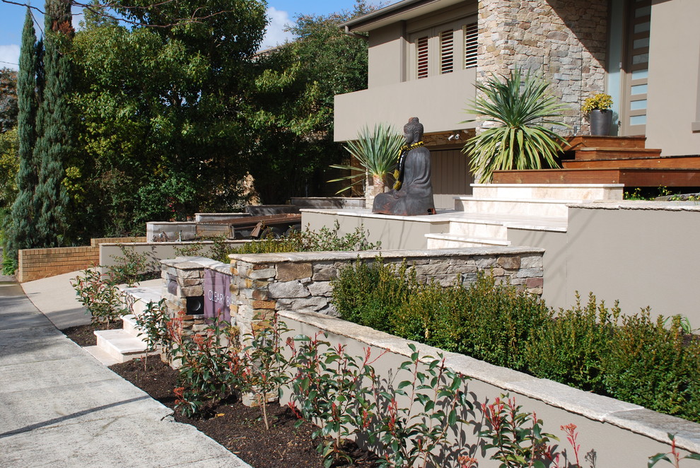 Ispirazione per un giardino formale minimal esposto in pieno sole di medie dimensioni e davanti casa in primavera con pavimentazioni in pietra naturale e recinzione in pietra