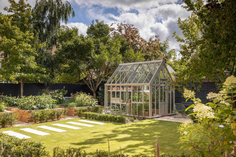 Cette photo montre un jardin chic avec une exposition partiellement ombragée et une clôture en bois.