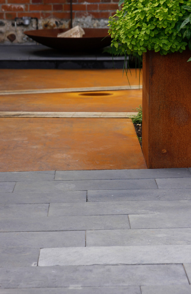 Photo of a small urban front formal partial sun garden for summer in Other with natural stone paving.