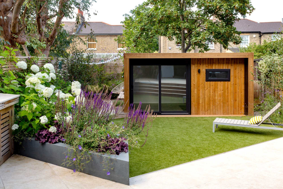 Kleiner Moderner Garten hinter dem Haus mit Hochbeet und Natursteinplatten in London