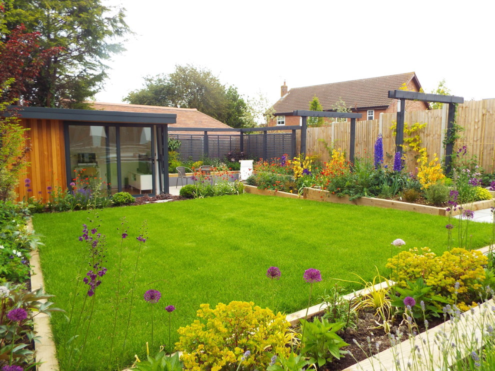This is an example of a medium sized contemporary back garden in West Midlands with concrete paving.