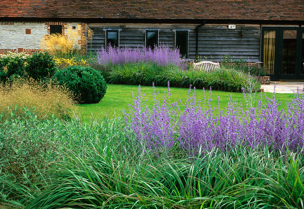 Immagine di un grande giardino country esposto in pieno sole dietro casa in estate