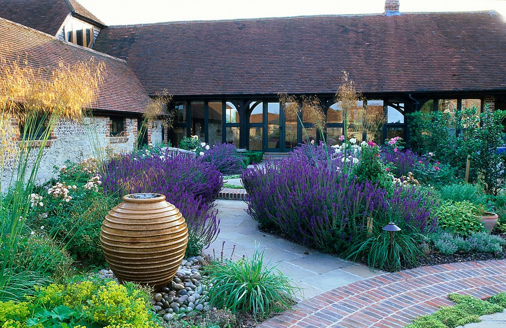 Immagine di un giardino formale country esposto a mezz'ombra di medie dimensioni e dietro casa in estate con un ingresso o sentiero e pavimentazioni in mattoni