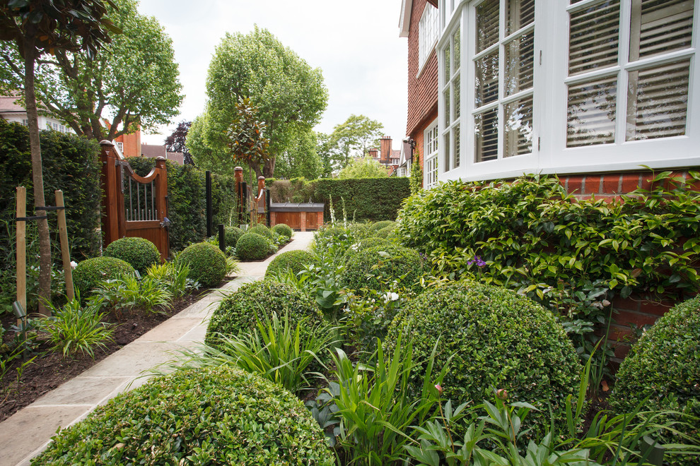 Стильный дизайн: летний регулярный сад на переднем дворе в классическом стиле с полуденной тенью и покрытием из каменной брусчатки - последний тренд