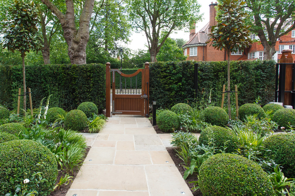 Diseño de jardín clásico en verano en patio delantero con jardín francés, exposición parcial al sol y adoquines de piedra natural