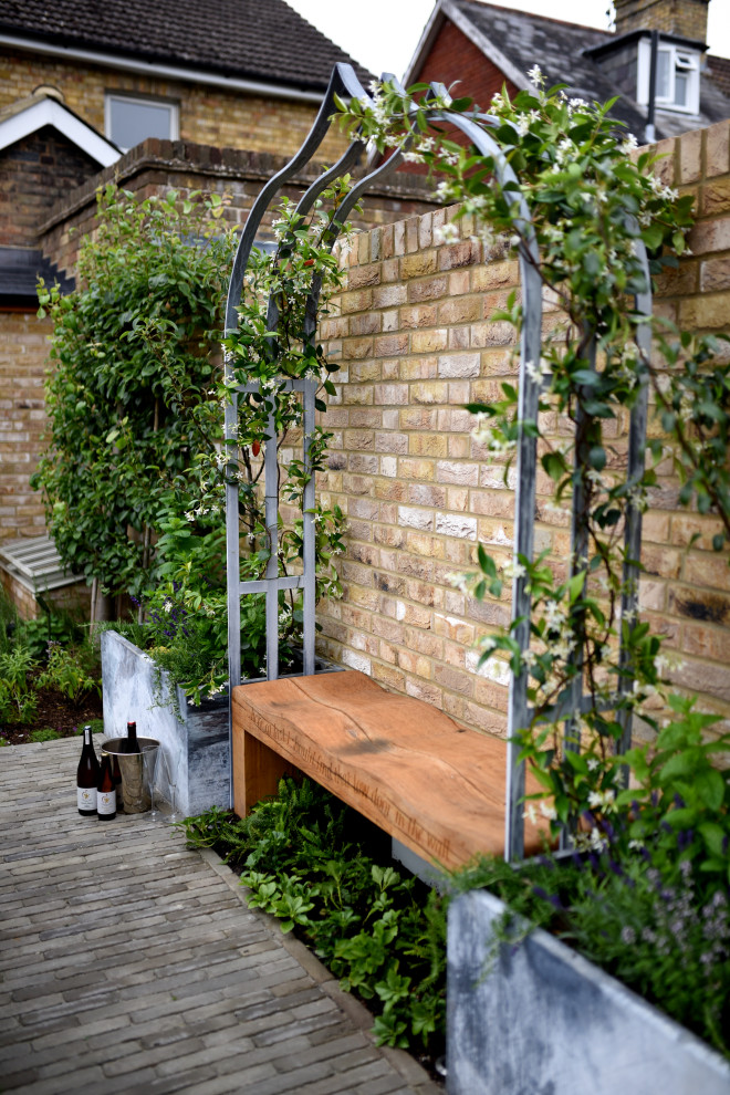 Foto de jardín tradicional pequeño en patio con jardín francés y adoquines de ladrillo