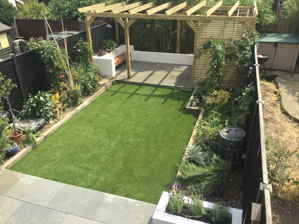 Medium sized contemporary back formal garden in London with a retaining wall.