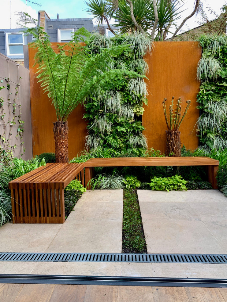 Ispirazione per un piccolo giardino design esposto a mezz'ombra dietro casa con pavimentazioni in pietra naturale