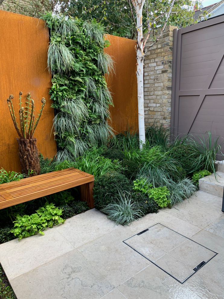 Design ideas for a small contemporary back partial sun garden in London with natural stone paving.