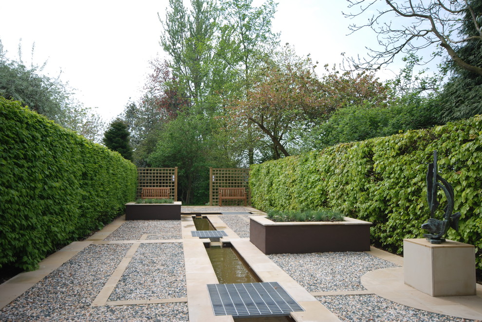 Immagine di un giardino formale contemporaneo esposto in pieno sole e stretto con ghiaia