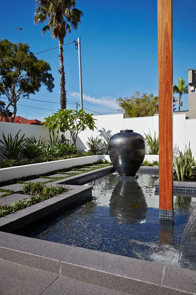 На фото: солнечный садовый фонтан в современном стиле с хорошей освещенностью