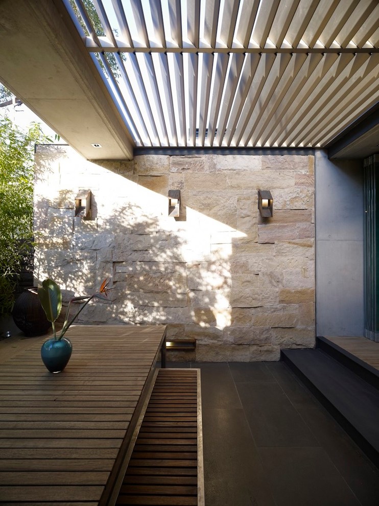 Inspiration for a small modern back formal partial sun garden in Sydney with a potted garden and natural stone paving.