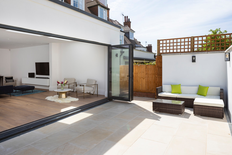 Photo of a mid-sized modern full sun and privacy backyard stone landscaping in London.