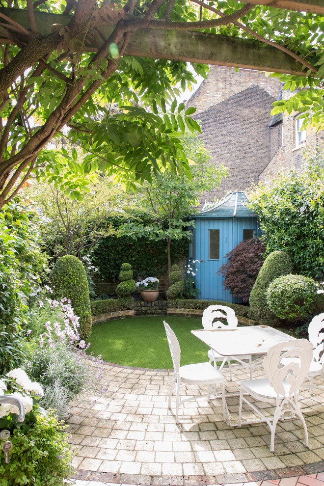 Inspiration for a classic garden in London with concrete paving.