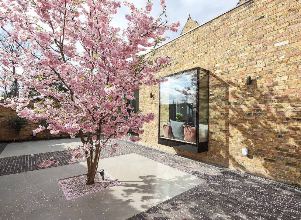 Immagine di un piccolo giardino minimalista esposto in pieno sole dietro casa in primavera con pavimentazioni in mattoni