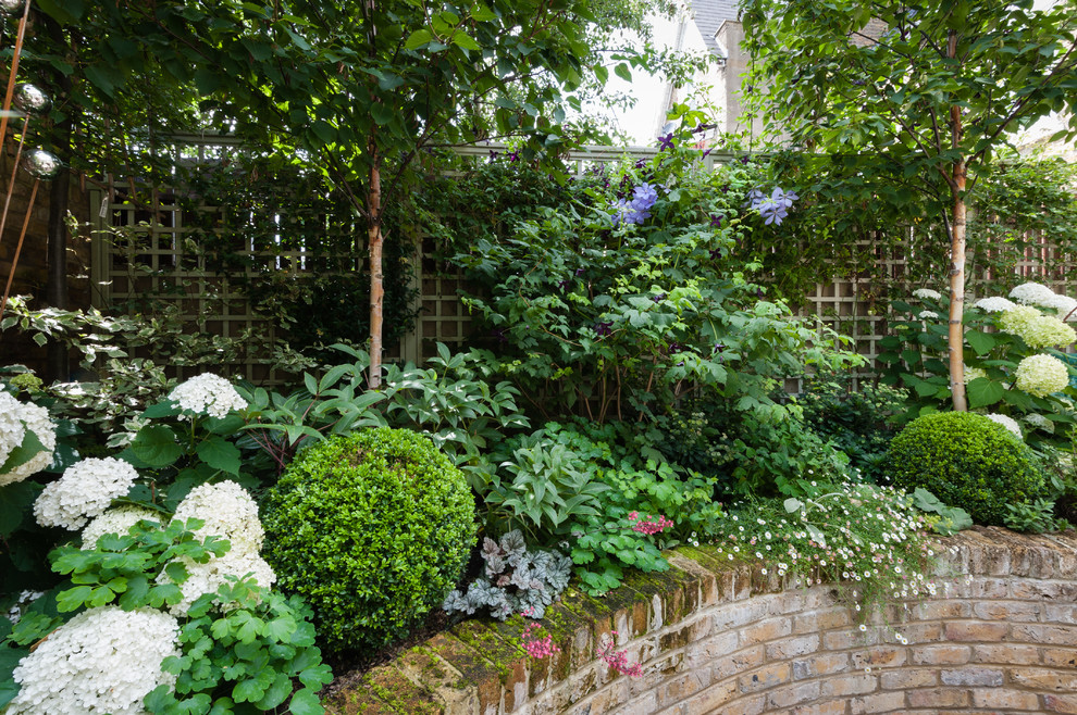 Idées déco pour un petit jardin classique au printemps avec une exposition partiellement ombragée et des pavés en brique.