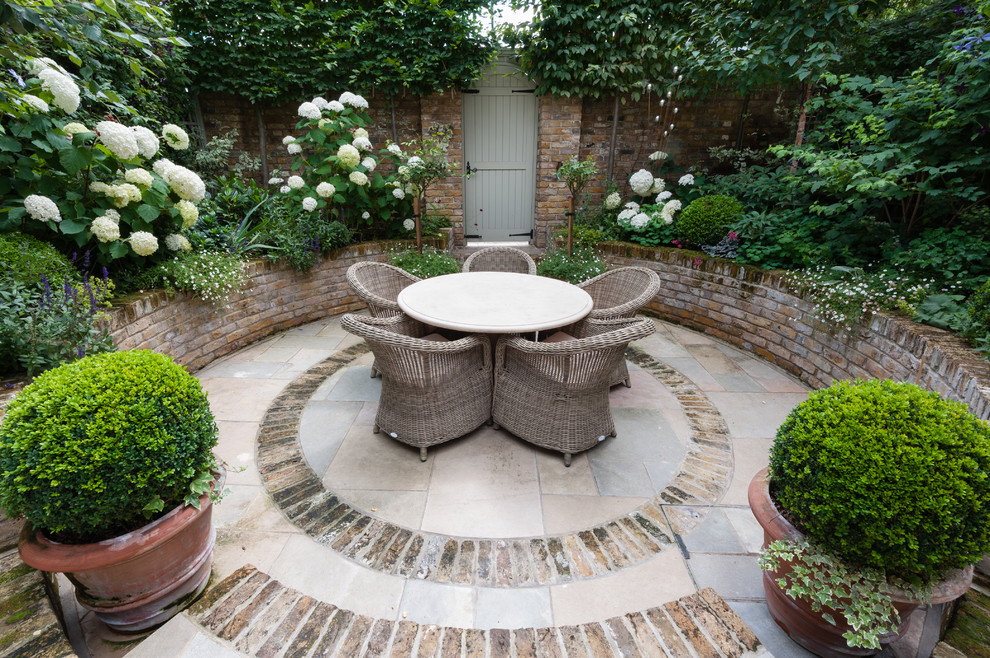 This is an example of a small classic courtyard partial sun garden for spring in London with an outdoor sport court and brick paving.
