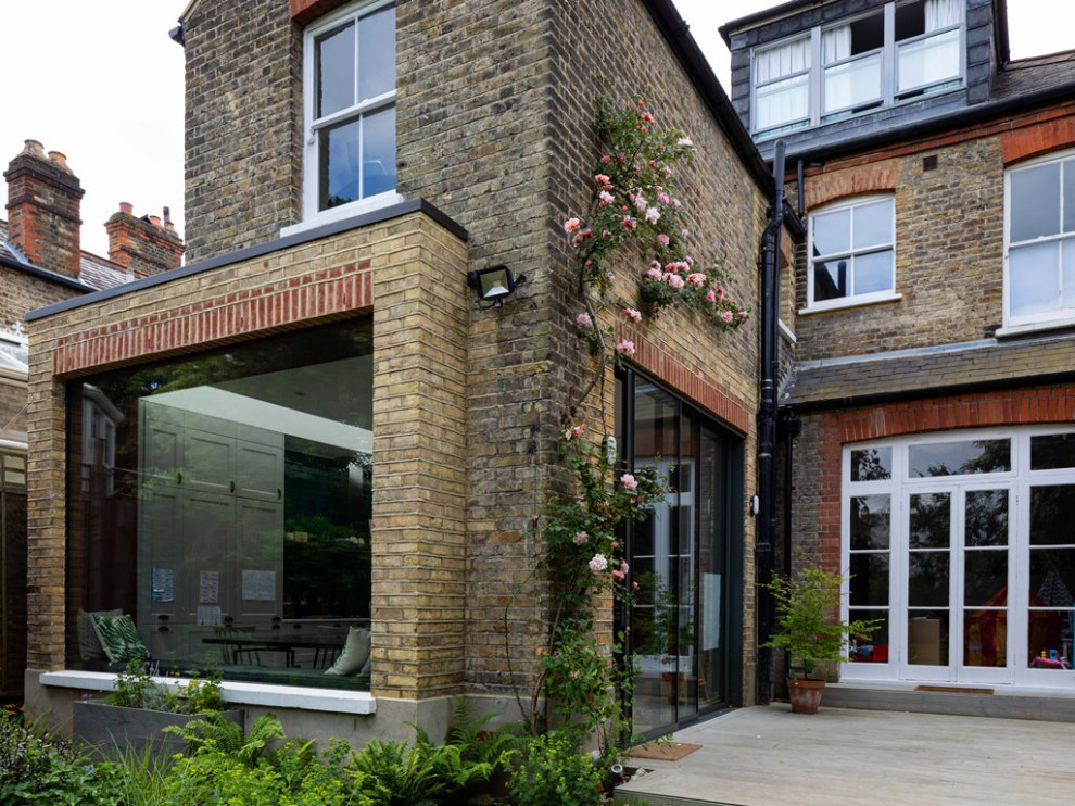 Photo of a mid-sized contemporary partial sun backyard landscaping in London with decking for summer.