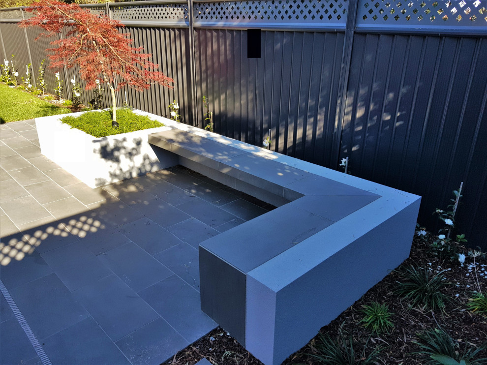 Geometrischer, Mittelgroßer, Halbschattiger Moderner Garten im Sommer, hinter dem Haus mit Blumenbeet und Natursteinplatten in Melbourne
