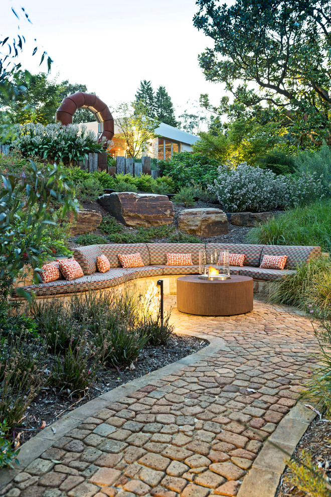 Diseño de jardín actual de tamaño medio en patio trasero con brasero
