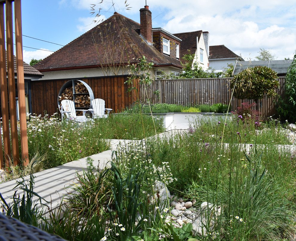 This is an example of a contemporary back full sun garden for summer in Buckinghamshire with a raised bed and decking.