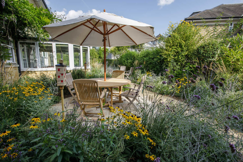 Mittelgroßer Landhaus Gartenteich hinter dem Haus mit Natursteinplatten in London