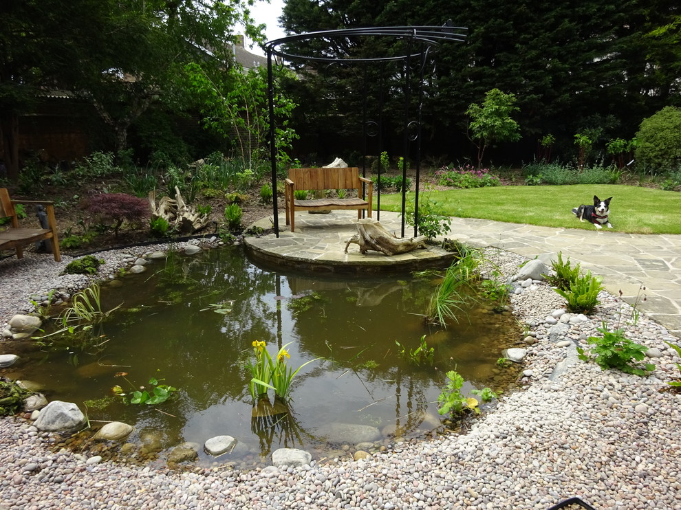 Idée de décoration pour un jardin arrière craftsman de taille moyenne et l'été avec un bassin, une exposition partiellement ombragée et des pavés en pierre naturelle.