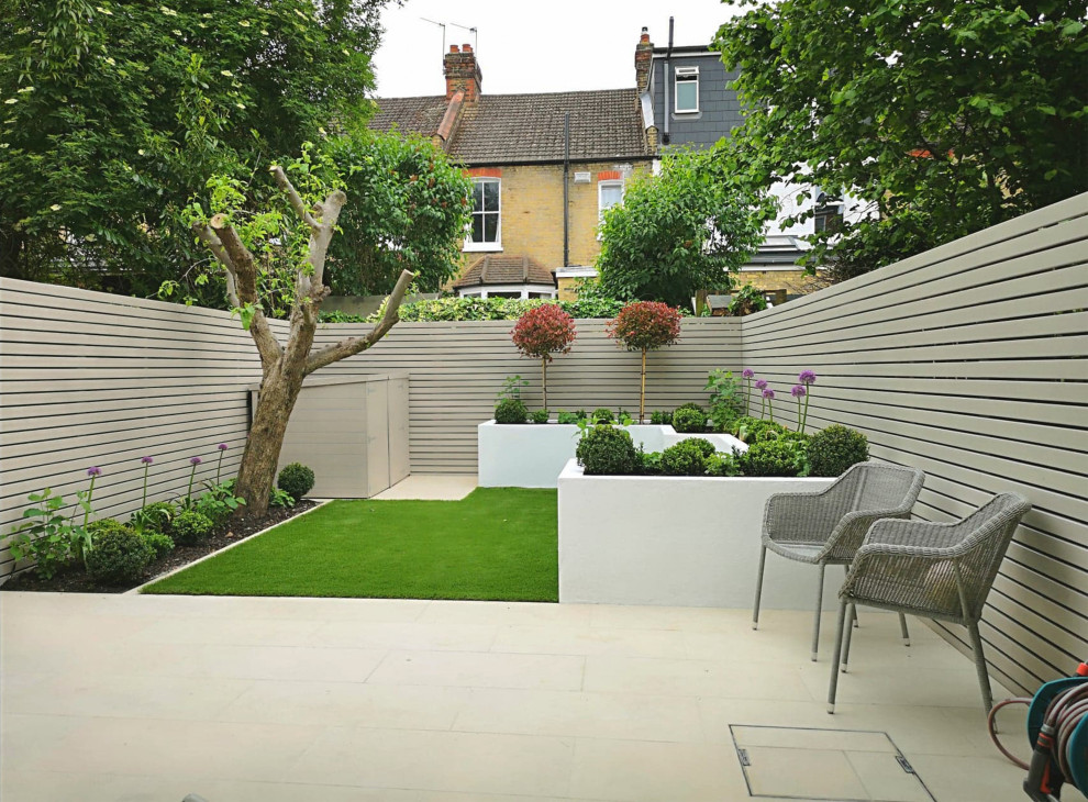 Small modern back partial sun garden in London with a raised bed.